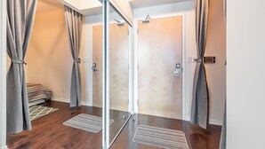 Ein modernes Zimmer mit einer Schiebeglasdoor, Holzböden und einem Bett mit einer gestreiften Decke.
