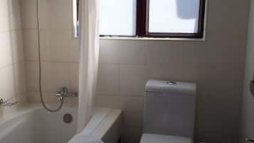 A bathroom with a bathtub, toilet, and sink.