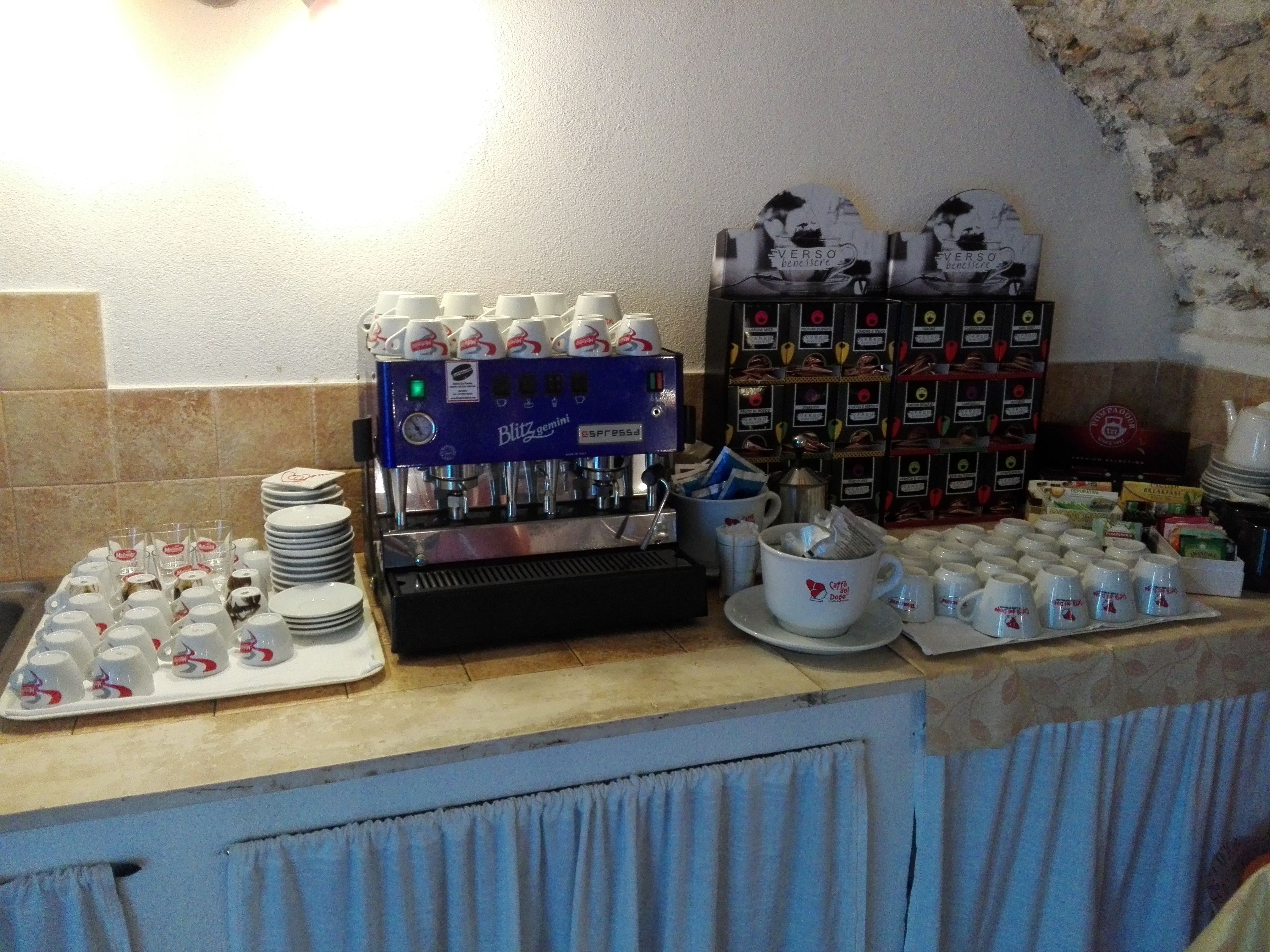 A coffee station with a coffee machine, cups, and various coffee products.