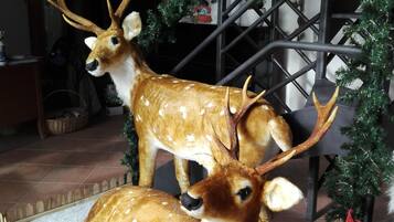 Zwei Hirschfiguren auf einer Plattform mit Zierzaun, umgeben von einem Weihnachtsbaum und einer Metallkonstruktion.