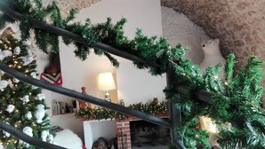 Un salon chaleureux avec une cheminée, un sapin de Noël et une lampe.