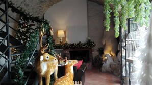 Une pièce avec une cheminée, un escalier et deux statues de cerfs.