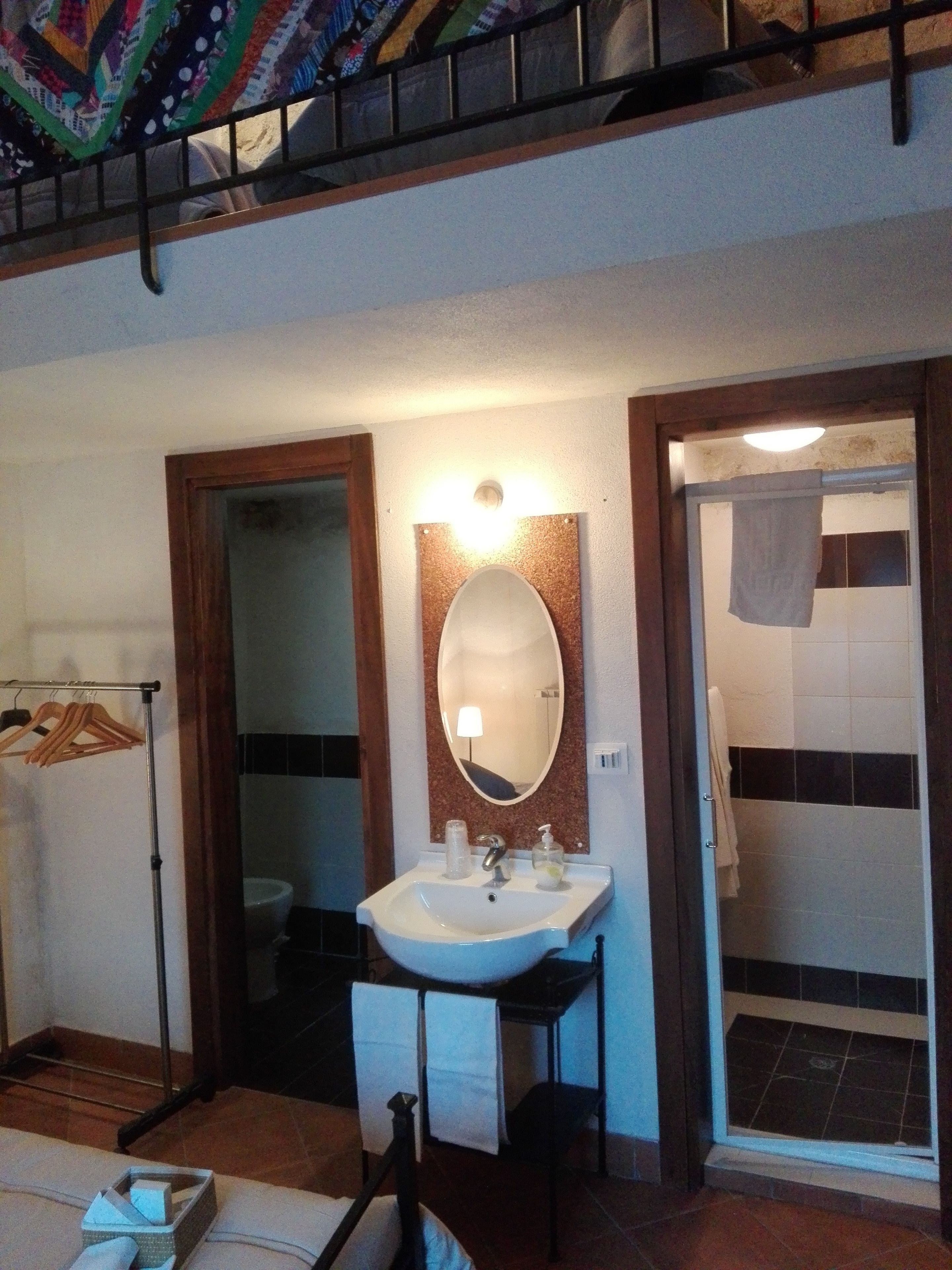 Une salle de bain équipée d’un lavabo, d’un miroir et d’un porte-serviettes.
