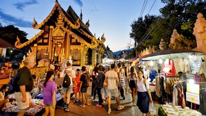 A traditional temple with ornate golden decorations and a bustling market with various stalls and people.
