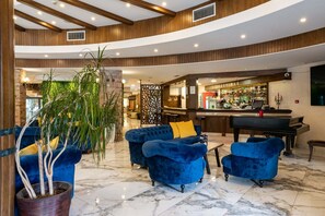 A lobby with a bar area, seating, and a piano. - Grand Hotel Velingrad (Velingrad)