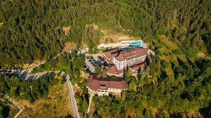 A lodge surrounded by dense forest, with a main building and a pool area. - Grand Hotel Velingrad (Velingrad)