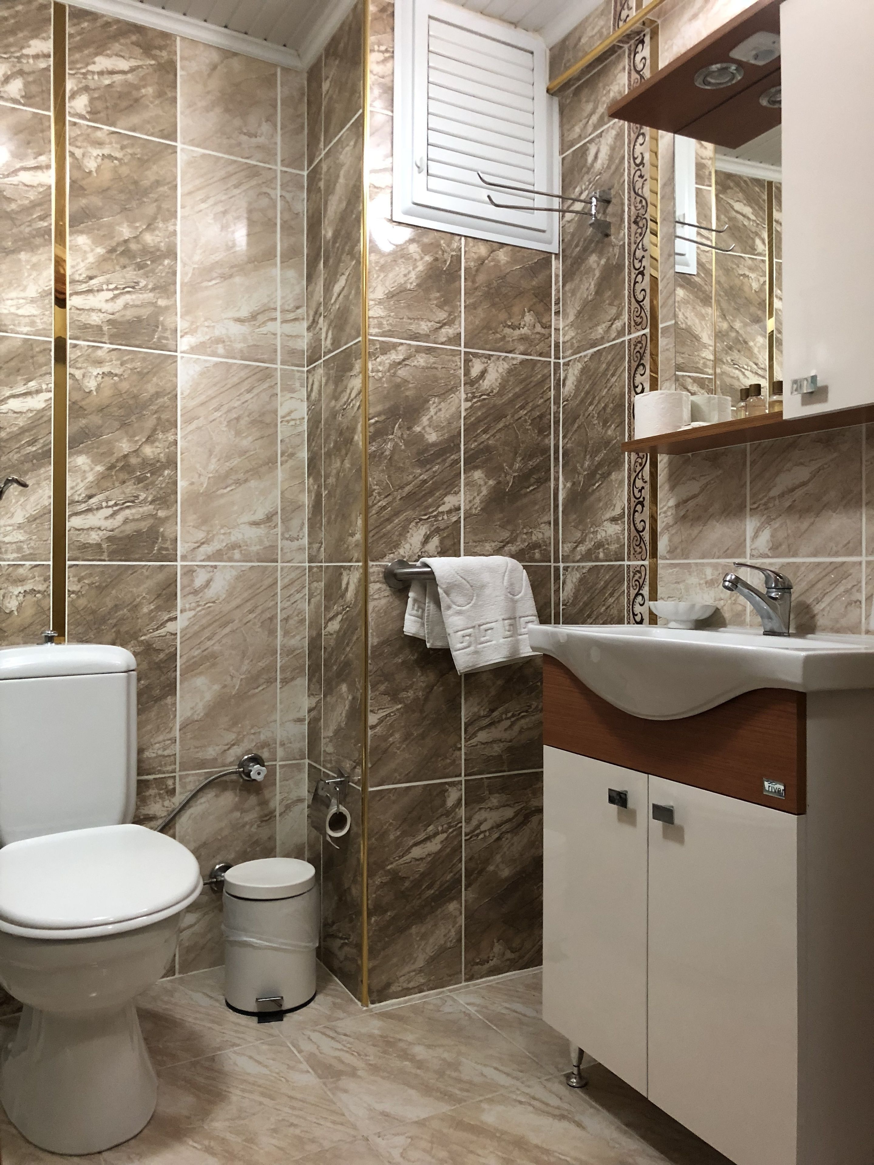 A bathroom with a toilet, sink, and shower area.