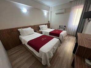 A hotel room with two beds, a wooden headboard, a desk, and a chair. - Hotel Cenka Ephesus (Selçuk)