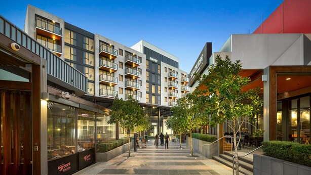 A modern hotel with a central courtyard, multiple balconies, and a restaurant named 'The Groove Train'. - Quest Epping (Epping)
