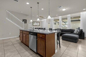 Enjoy a stylish kitchen and living space with a central island, dishwasher, and sink, perfect for cooking and relaxing.