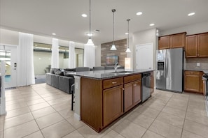 Enjoy cooking in this well-equipped kitchen with a central island, sink, and appliances.