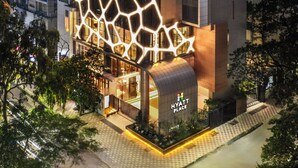 Een modern hotel met een opvallende geometrische gevel en een zichtbaar logo.