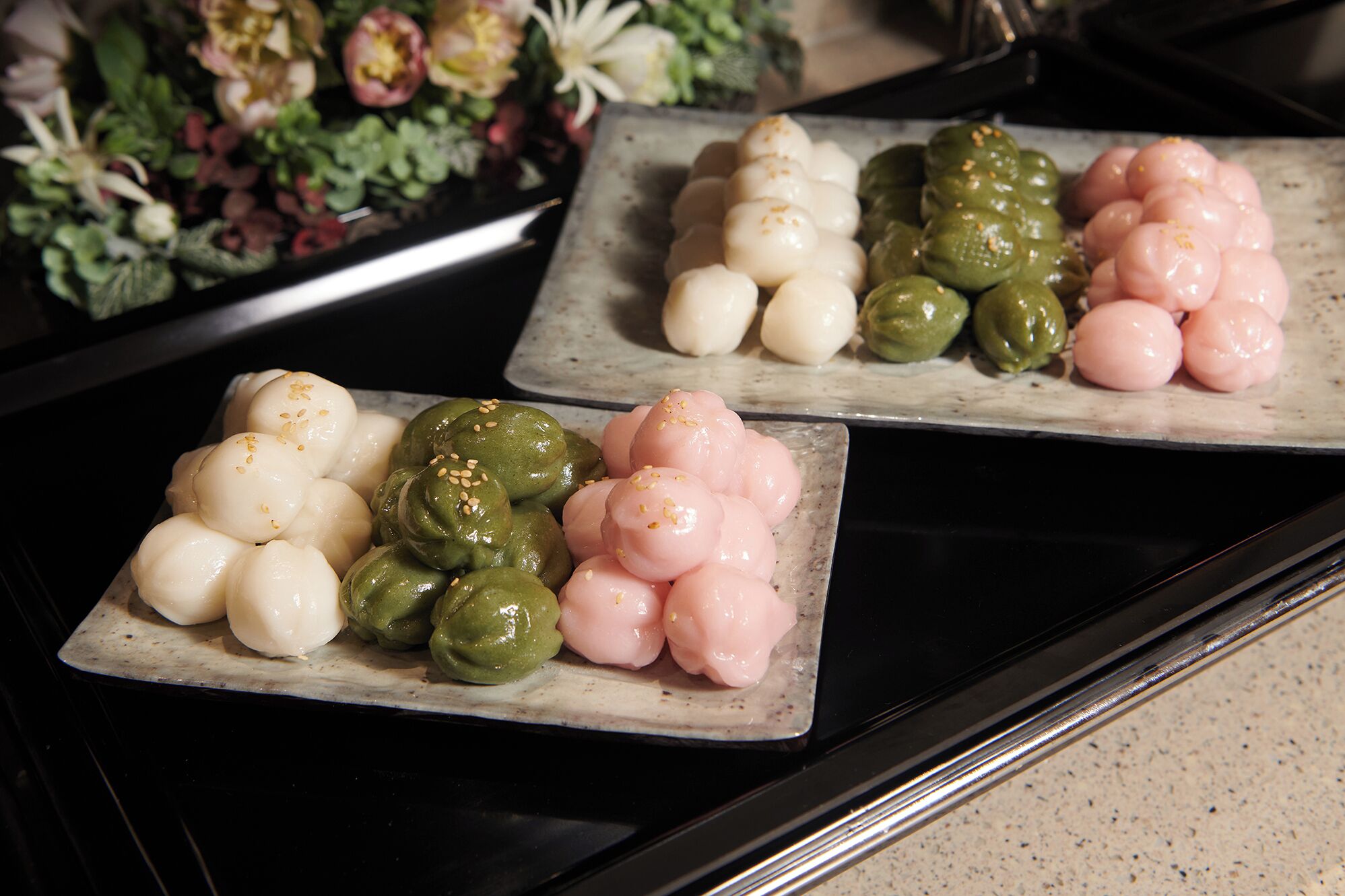 Three square plates with different colored and shaped food items.