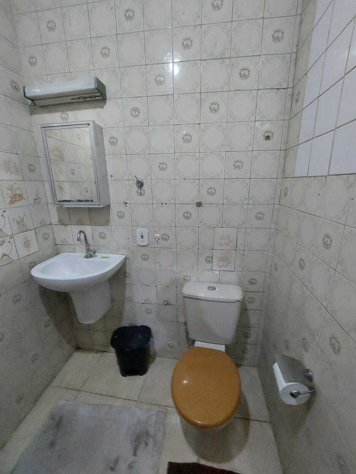 A small bathroom with a white sink, a toilet, and a mirror.