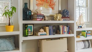 A well-organized room with white shelving units, a framed artwork, and various decorative items. - Superb Location! 5min walk to town & EV charger port (Camden)
