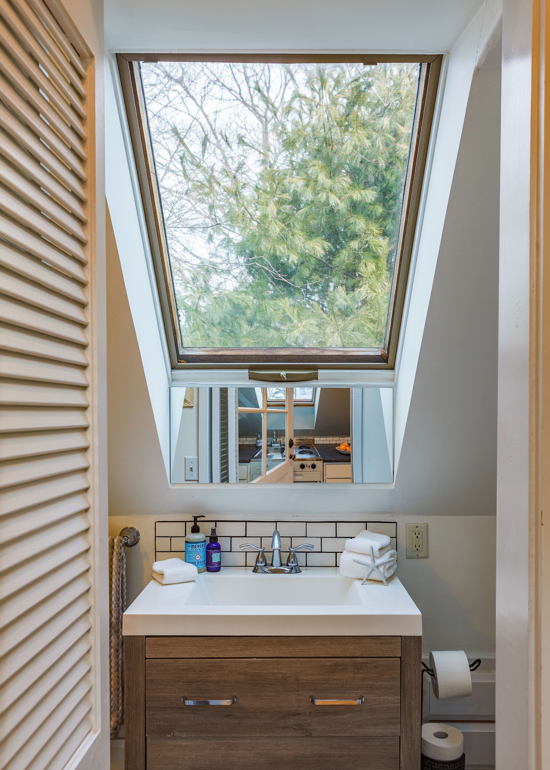 A bathroom with a skylight, a sink with a mirror, and a towel rack. - Superb Location! 5min walk to town & EV charger port (Camden)