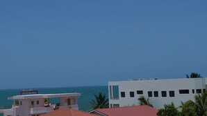 Vista costera con edificios modernos, cielos despejados y el mar al fondo.