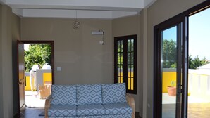 Una sala de estar con sofá, mesa de centro y puerta corrediza de vidrio que da a un espacio exterior.