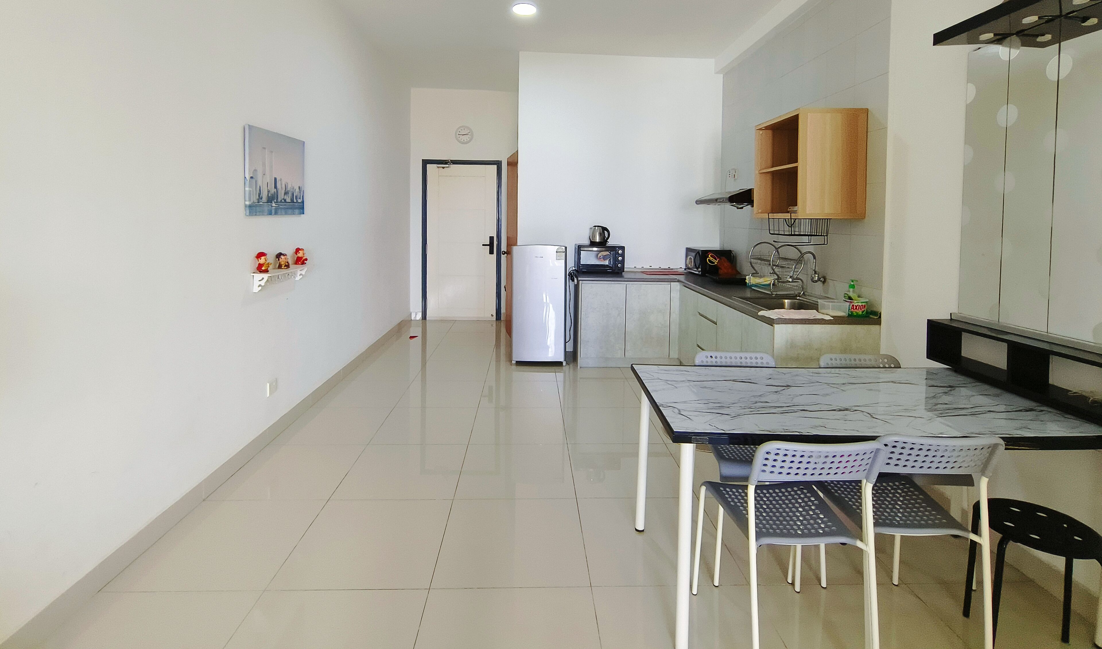 Une cuisine moderne équipée d’un réfrigérateur, d’un four à micro-ondes et d’un évier. Un coin repas avec une table et des chaises est également disponible.
