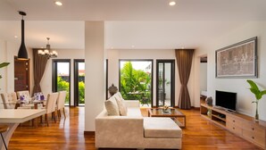 A modern living room with a sofa, coffee table, and dining area.