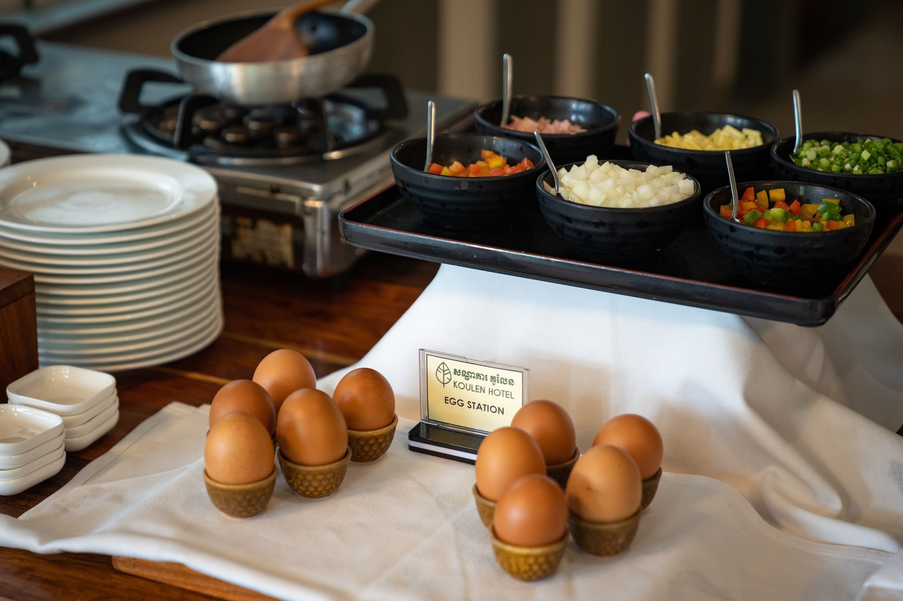 A buffet setup with various food items and a sign indicating an egg station.