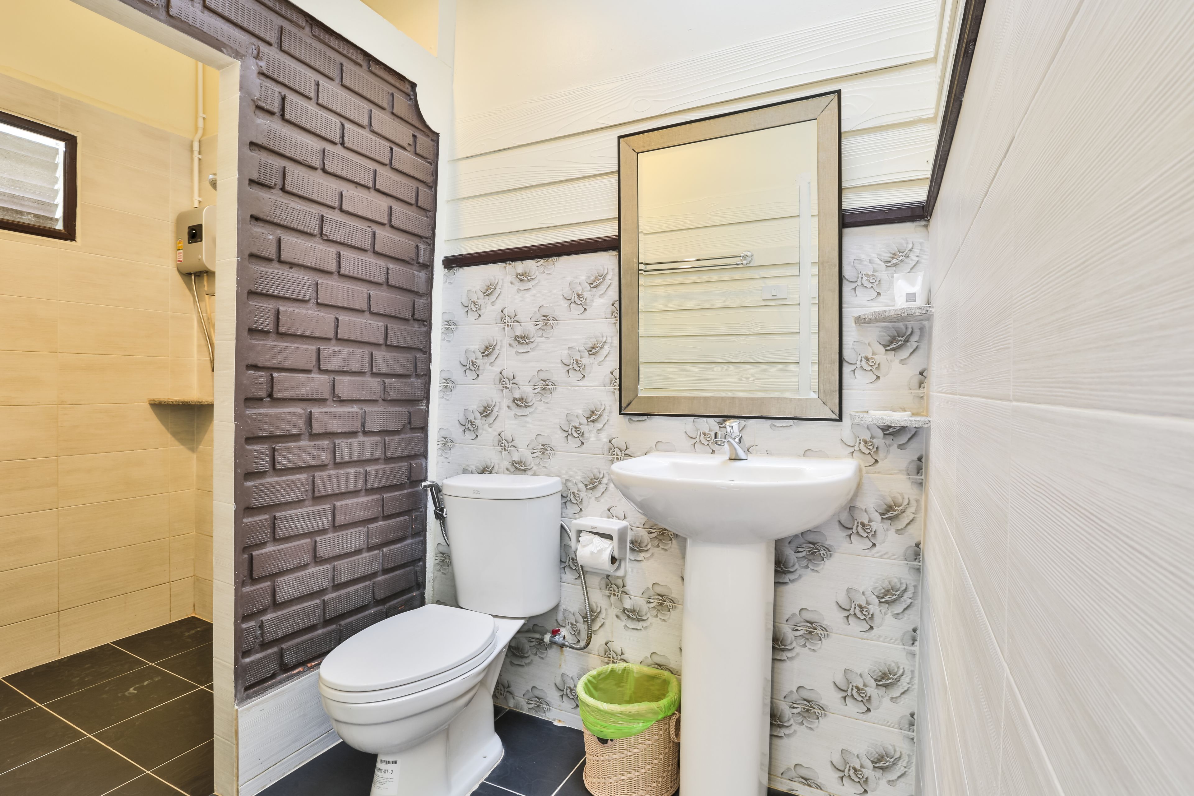 A bathroom with a toilet, sink, and a mirror.