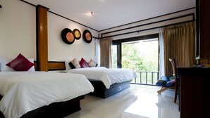 A modern hotel room with two beds, a balcony, and a view of greenery. - Lampam Resort (Phatthalung)