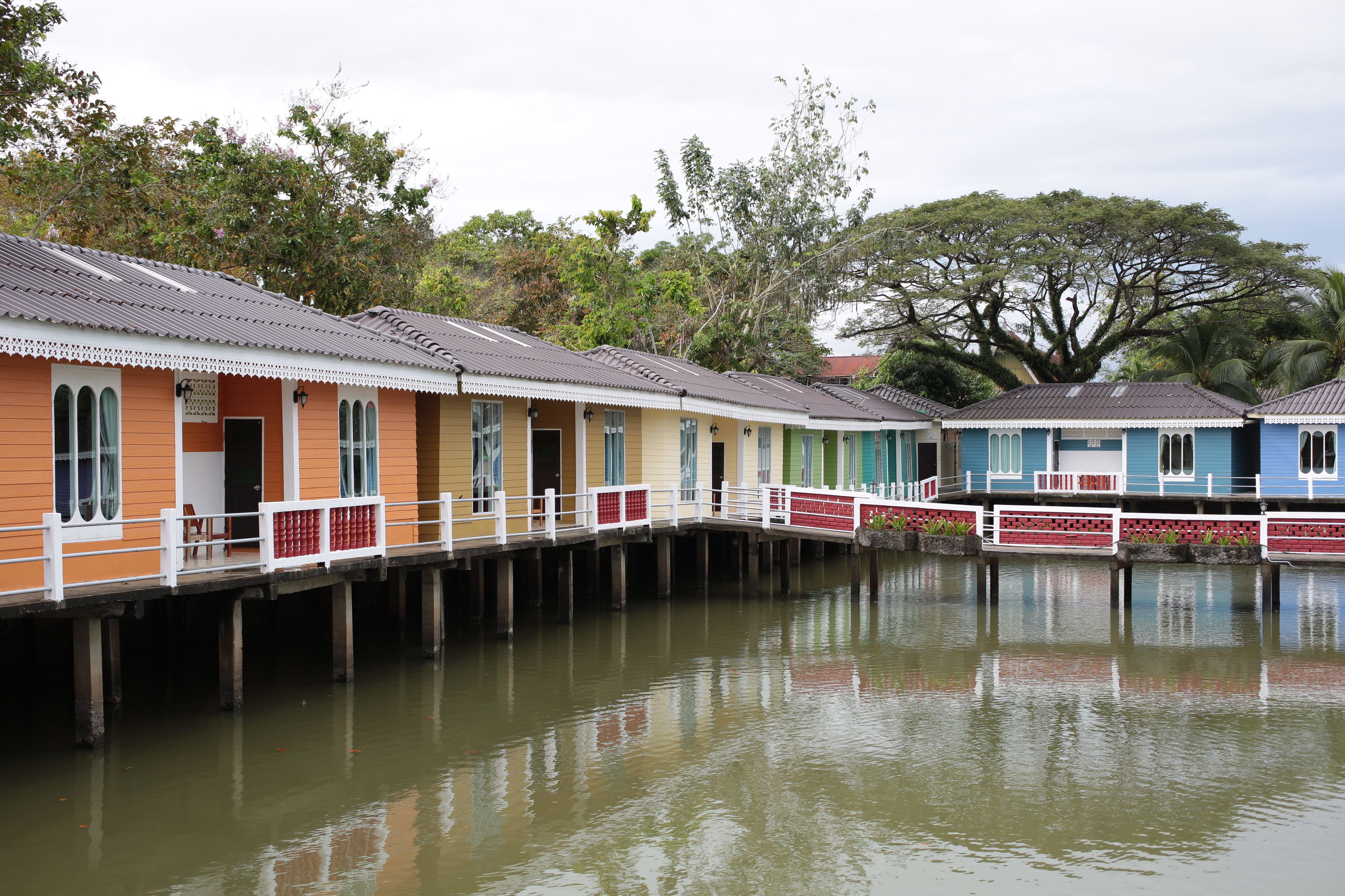 Une rangée de maisons flottantes dotées d’une terrasse en bois et offrant une vue sur l’eau.