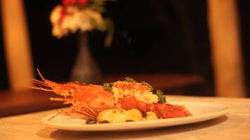A plate of food with shrimp and vegetables on a table.