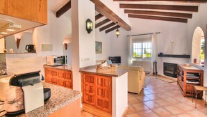 Une cuisine spacieuse avec des meubles en bois, un four à micro-ondes encastré et un grand îlot central.