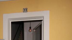 Une porte avec un panneau de verre, un escalier à l’intérieur et un carillon.