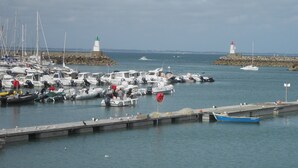 A marina with multiple boats docked, a lighthouse, and a rocky breakwater. - Nice sea view, south facing, Wifi, Parking, 50 m from beach & Thalasso (Quiberon)