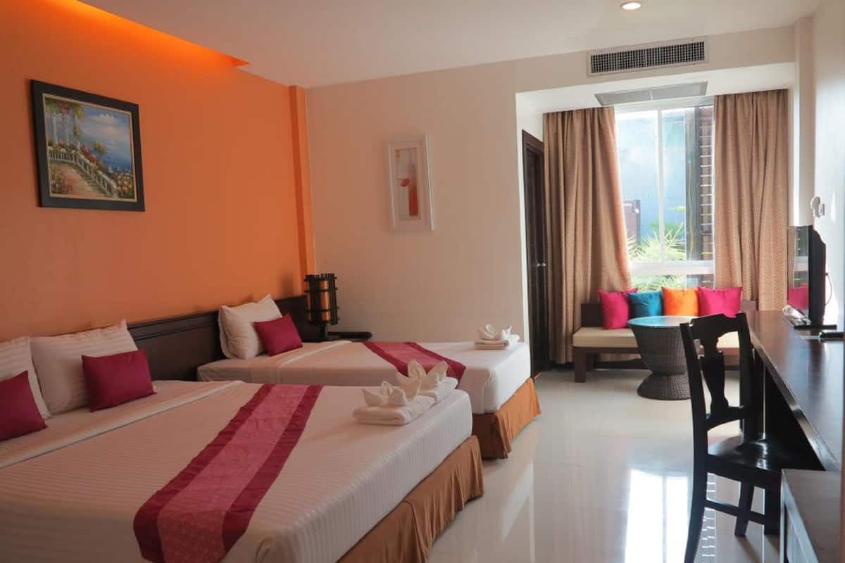 Une chambre d’hôtel avec deux lits, un coin repas et une vue sur l’extérieur.