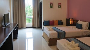 A hotel room with two beds, a desk, a television, and a window with curtains.