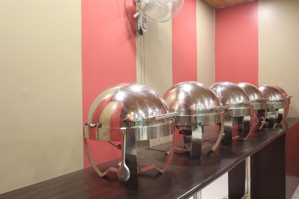 Una barra de buffet con varias estaciones de comida cubiertas.