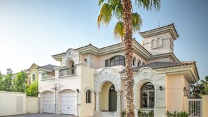A Mediterranean-style house with a two-story facade, a front entrance with a door, and a garage. - Dream Inn Dubai-Palm Island Retreat Villa (Dubai)