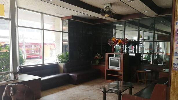 Eine Lobby mit einer Couch, einem Glastisch, einem Fernseher und einer dekorativen Elefantenstatue.