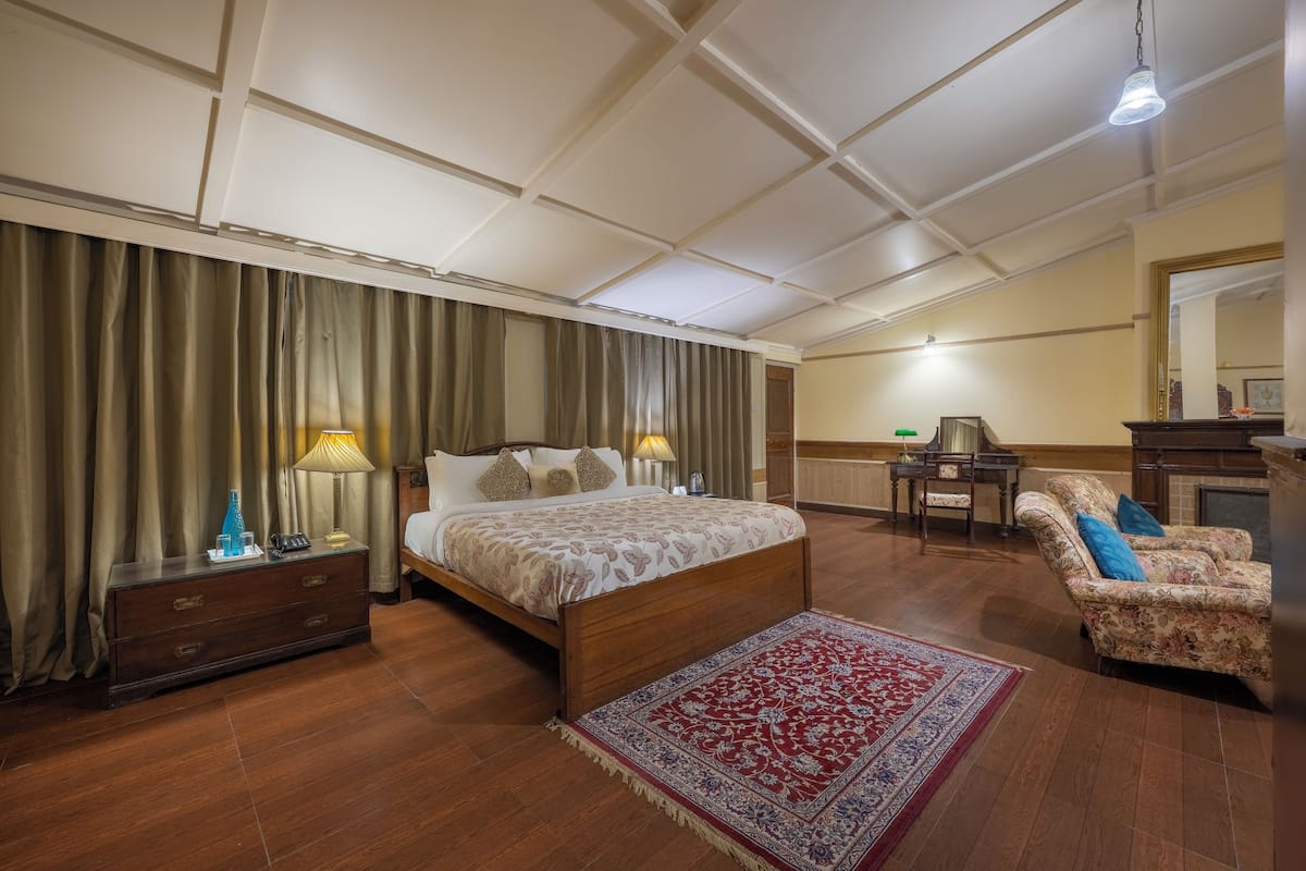Un dormitorio amplio con una cama grande, una zona de estar con sofá y una mesa de comedor.