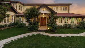 A two-story building with a central entrance, surrounded by a well-maintained lawn and trees. - Springfields by Eastlynn Collections - A Heritage Palace Since 1902 (Shimla)
