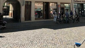 A historic building with a cobblestone street in front.