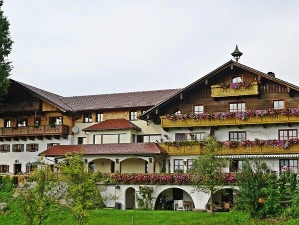 A traditional multi-story building with balconies, arched walkways, and a central courtyard.