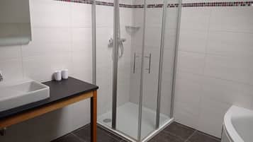 Ein Badezimmer mit Duschkabine, Waschbecken und Toilette.