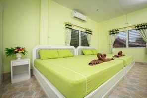 A room with two beds, a nightstand, and a window with curtains.