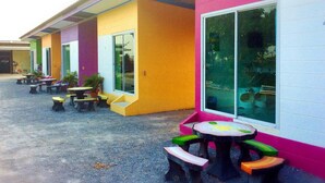 Un edificio colorato con posti a sedere all'aperto e ampie finestre.