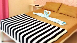 Una camera d'albergo con un letto, un comodino, una tenda rosa e una parete decorata.