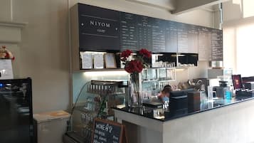 A cafe interior with a menu board, a wine list, and a refrigerated display.