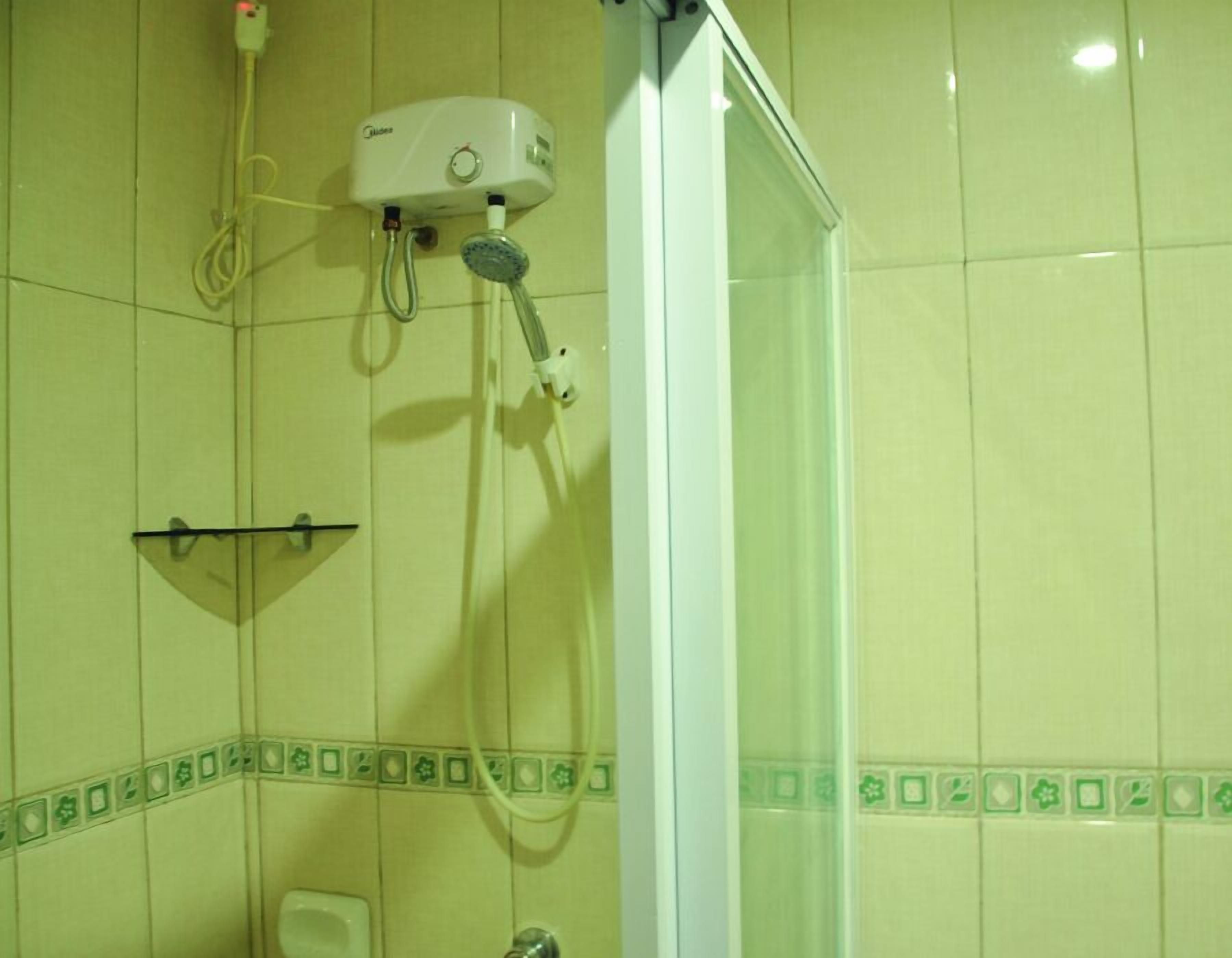 A shower with a handheld showerhead and a wall-mounted control unit.