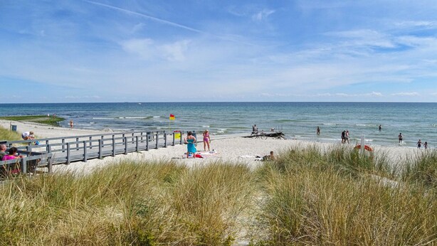 A beach with a wooden walkway, people sunbathing, and the ocean in the background. - Gorgeous home in Grenaa with sauna (Grenaa)