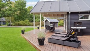 A deck with outdoor furniture, a barbecue grill, and a covered patio area. - Gorgeous home in Grenaa with sauna (Grenaa)