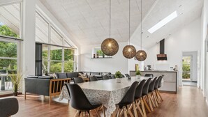 A spacious dining area with a long table, black chairs, and a modern chandelier. - Gorgeous home in Grenaa with sauna (Grenaa)
